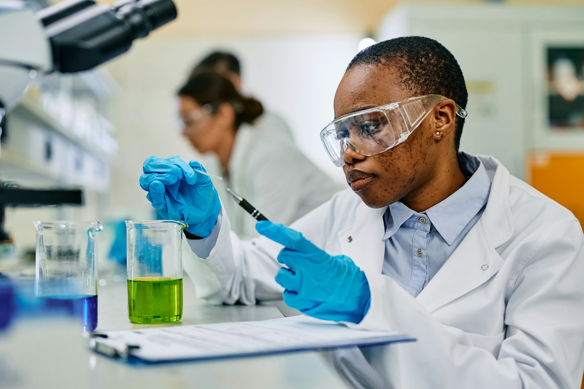 Black female microbiologist doing a research in pharmaceutical laboratory.